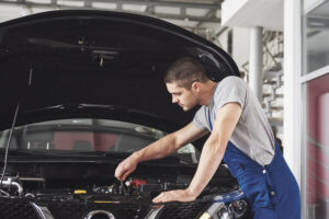 Auto mechanic working in garage. Repair service.